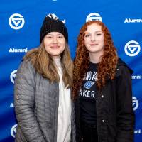 Two young women standing in front of GV Alumni backdrop, posing for photo
